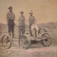 Occupational portrait of three railroad workers standing on crank handcar, between 1850 and 1860
