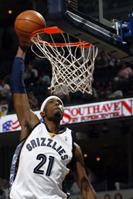 A professional basketball player executes a slam-dunk.