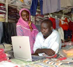 
美國國際開發署(USAID)贊助的"信息技術自由行動計劃"( Digital Freedom Initiative)的志願人員法庫巴&middot;蓋伊(Facoumba Gueye，左)向服裝商奧馬爾&middot;福爾(Omar Fall)解釋如何利用信息技術提高效率和利潤。美國國際開發署通過這一項目與美國大公司共同幫助發展中國家的創業者和小企業拓展業務。