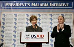 第一夫人勞拉&middot;布什(Laura Bush)於2006年6月在華盛頓特區就總統抗擊瘧疾行動計劃增加資金髮表講話，圖中鼓掌者為美國對外援助事務主任兼美國國際開發署署長托拜厄斯(Randall Tobias)。
