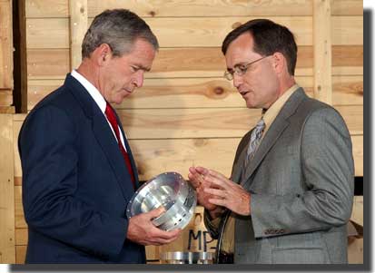 President Bush holds a centrifuge component from Libya