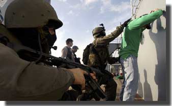 Special Operations Forces from Spain search a sailor after boarding the USNS Saturn