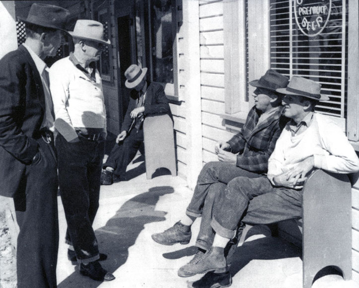 Historic photo of men next to a building wearing hats