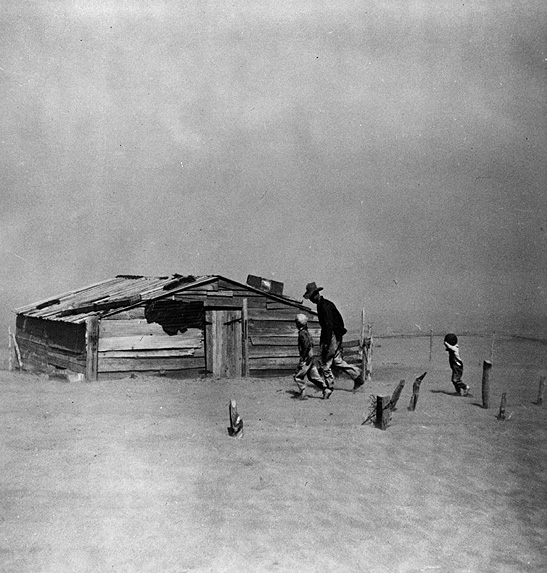 A farmer and his sons walk in a dust storm in Oklahoma in 1936.