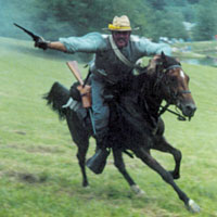 Photo of re-enactor on horseback charging with gun