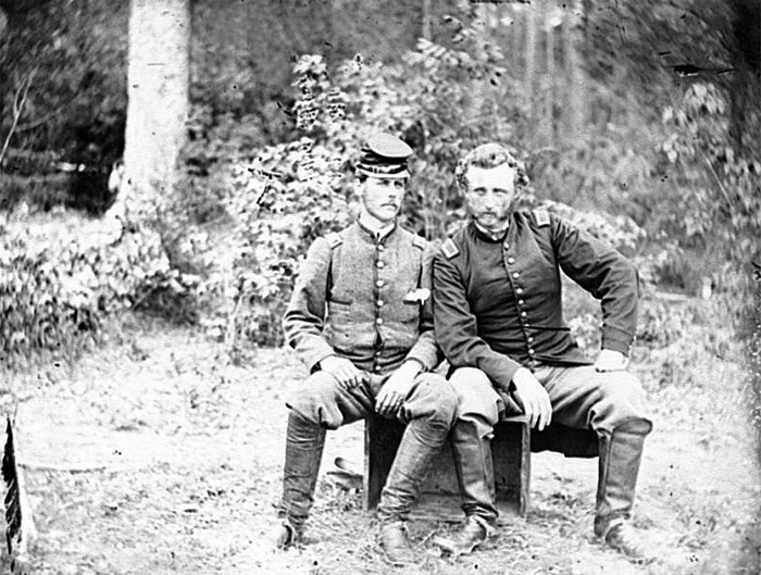 Confederate prisoner sits with Captain George Custer