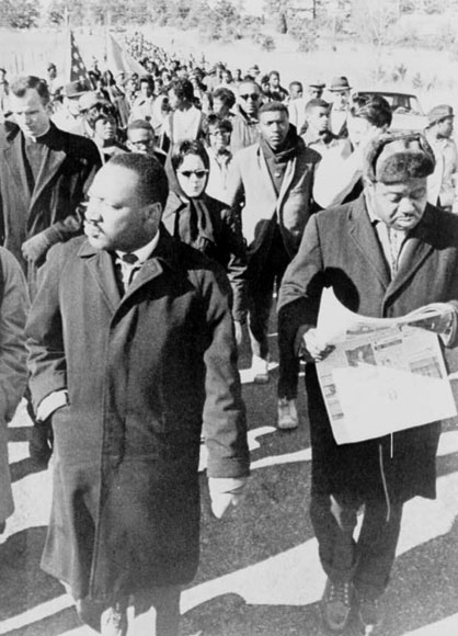 Rev. Ralph Abernathy walking with Dr. Martin Luther King, Jr., as they lead civil rights marchers out of camp to resume their march