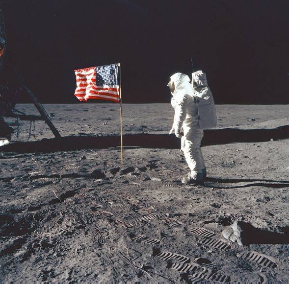Neil Armstrong on the moon poses next to the Unites States flag, July 20, 1969