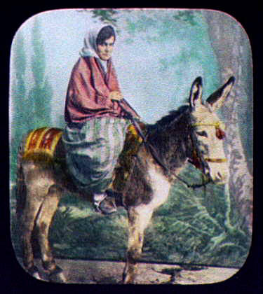 Young woman riding burro.