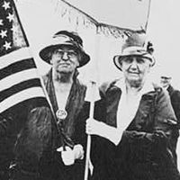 Jane Addams and Mary McDowell(?), full-length portrait, standing, holding U.S. flag and peace banner