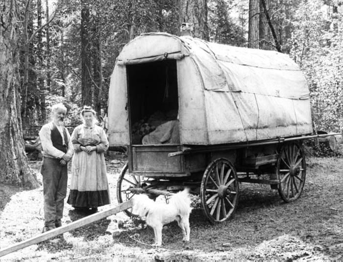 A man and woman with a covered wagon, Prospect, Oregon.